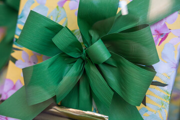A huge green gift bow on a box containing a congratulatory, wedding, or event gift.