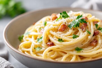Creamy pasta carbonara garnished with pancetta and parsley served in a rustic bowl