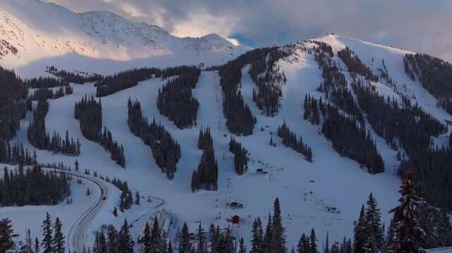 Loveland Pass sunset Arapahoe Basin Basin Abay Ski Resort Colorado aerial drone winter spring last light golden hour groomed ski trail runs chairlift main lodge Base Area parking lot forward pan up