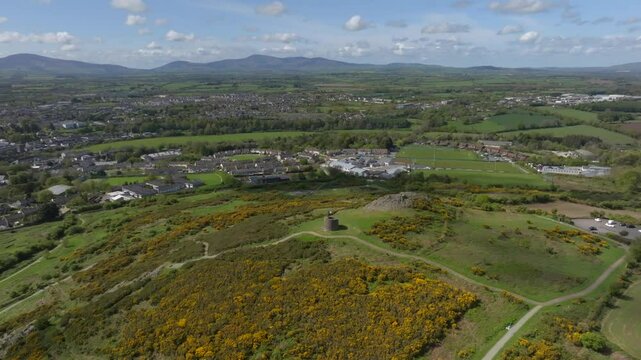 Vinegar Hill, Enniscorthy, County Wexford, Ireland, April 2025. Drone high angle panoramic establishing overview of tower monument and nearby town with dense buildings built up around River Slaney.