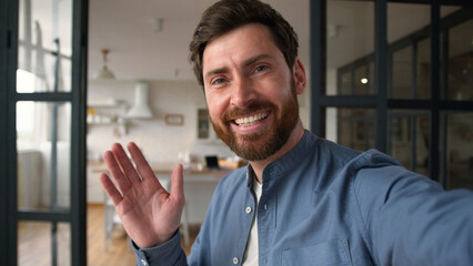 Glad Caucasian man male father smiling recording video blog speaking camera mobile phone tech at...
