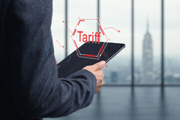 Businessman Holding Tablet with Tariff Concept in Modern Office