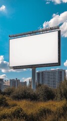 Blank billboard in urban park with skyscrapers under clear sky