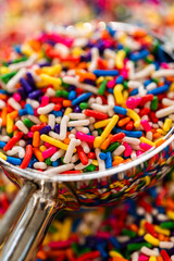 Glass scoop filled with multicolored sprinkles