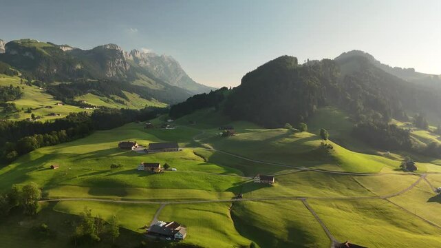 Aerial View of Swiss Countryside Near Hoher Kasten with Green Hills, Meadows, and Mountains at Sunset
