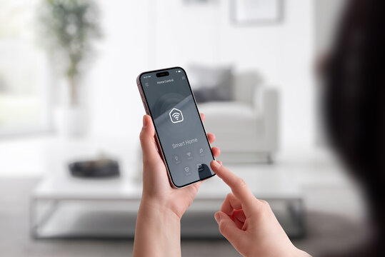 Woman interacting with smart home interface on mobile phone in modern interior environment - Powered by Adobe