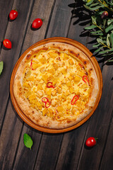 Delicious pizza topped with chicken and peppers on a rustic wooden table