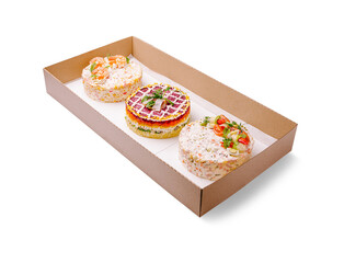 An elegant catering box featuring three beautifully styled layered salads shaped like cakes