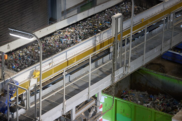 RDF fuel production line with municipal waste on a conveyor belt in Waste-to-Energy plant. Ideal for: recycling, sustainable energy, waste management, environmental protection.