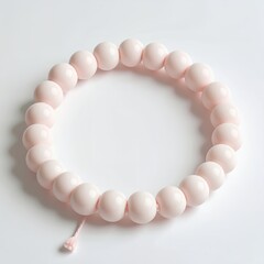 Obraz premium Elegant blush-toned spherical bead bracelet creating a circular pattern, minimalism on white background