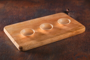 Empty wood cutting board on dark background. Empty wooden cutting board on a brown texture...
