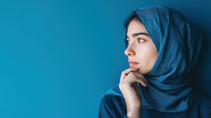 Woman in a blue hijab looking to the left