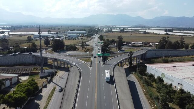 Aerial view of Guadalajara-Colima highway at the entrance to Ciudad Guzman with fields and traffic