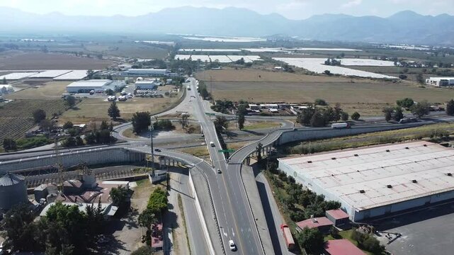 Aerial view of road interchanges and bridges near Ciudad Guzman, surrounded by farms and hills