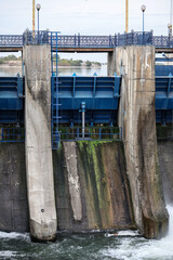 Overflow gate opened on a big concrete dam. Large volume of water flowing at high pressure.