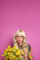An autumn portrait of a young woman in warm tones, holding a bouquet of yellow leaves, radiating seasonal charm and gentle joy.