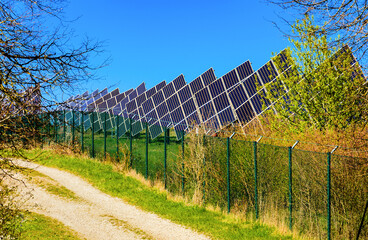 Umzäunte Solarfarm vor blauem Himmel