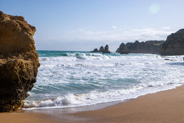 Fototapeta premium Golden Sea Cliffs and Rock Formations on a Sunny Algarve Beach
