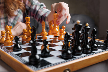 Chess Tournament Game in Progress with Female Player Strategizing Next Move