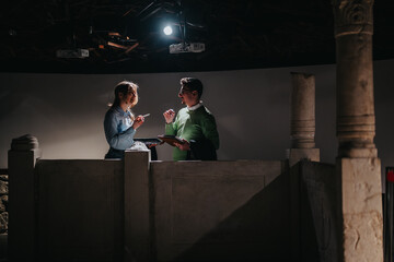 Two people engage in a conversation within a museum, surrounded by religious artifacts and...