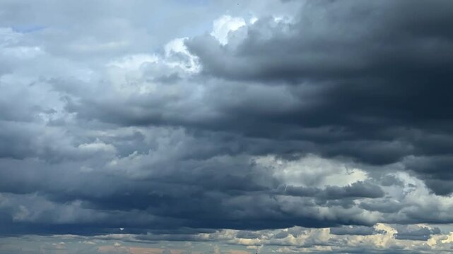 Dramatic dark cloudscape covering the sky. Low angle view at the clouds gathering in the atmosphere.