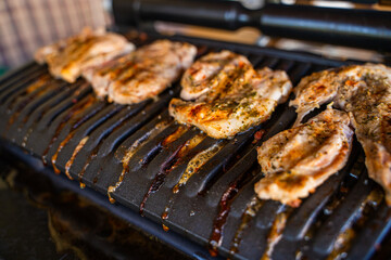 Pork steak being grilled on an electric grill, close-up