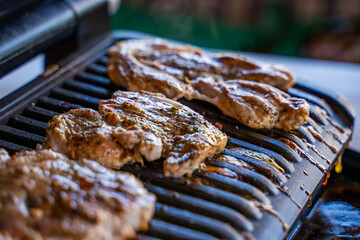 Pork steak being grilled on an electric grill, close-up