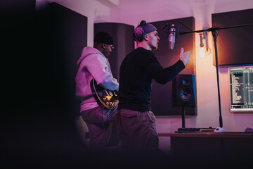 Two musicians working together in a professional recording studio, surrounded by high-quality audio...