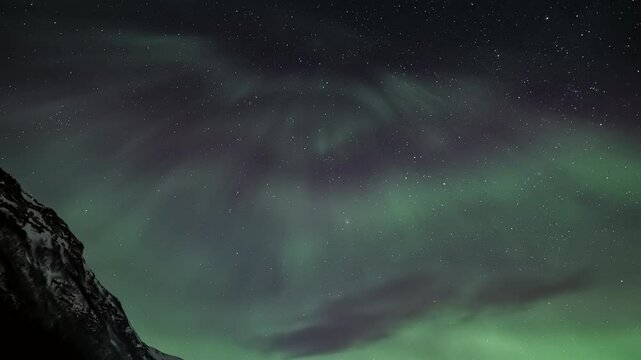 Aurora borealis above a snowy mountains, tilt up