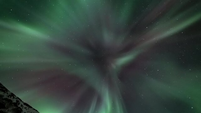 Full-sky aurora above a snowy mountain