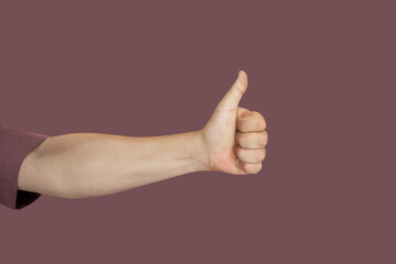 A human hand extends with the thumb pointing upwards, conveying approval, agreement, or success....