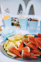 Colorful fruit platter with decorative picks at a festive gathering outdoors