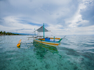 Moored Outrigger Bangka Boats Against a Dramatic Limestone Shoreline in sunny paradise Pescador...