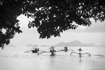 BW Anchored Bangkas boat in white water Sea in Panglao Beach, Bohol, Philippines
