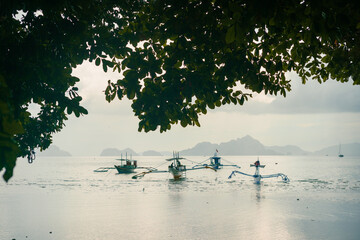 Golden Hour with Anchored Bangkas boat in blue water Sea in Panglao Beach, Bohol, Philippines