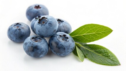 A pile of fresh blueberries with green leaves isolated on white background