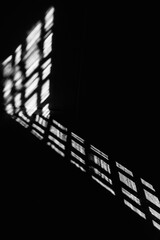 Abstract background, the shadow of a window frame cast on a dark surface. The strong contrast.