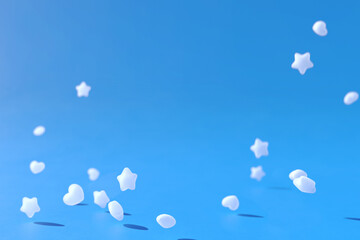 Star and Heart shaped Ramune Particles on blue background