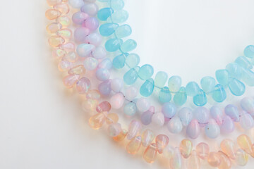 Colorful Opal Beads in Soft Pastel Shades on White Background

