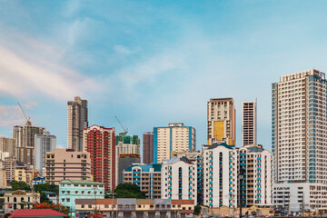 Binondo’s modern skyline and bridges over the Pasig River with a dense urban sprawl and mountains...