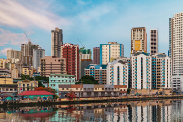 Binondo’s modern skyline and bridges over the Pasig River with a dense urban sprawl and mountains...