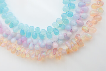 Colorful Opal Beads in Soft Pastel Shades on White Background

