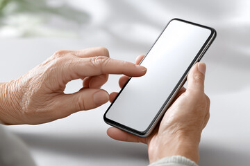 スマートフォンを操作する高齢者の手元＿ブランクスクリーン（スマホ画面はブランク処理されており、合成用途に適しています）