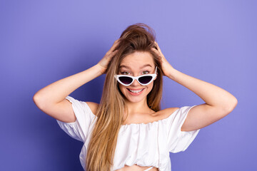 Young woman with stylish sunglass showcasing vibrant and trendy style against a vivid purple...