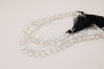 Faceted Moonstone Beads with a Soft Rainbow Sheen on a Neutral Background

