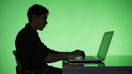 Side-view silhouette of a person working on a laptop, fingers tapping keys, chroma green background for overlay use, tech workspace pose, minimalist modern posture - Powered by Adobe