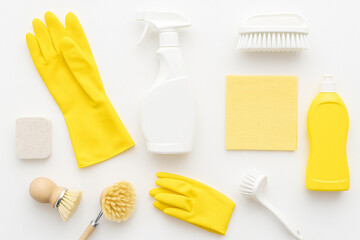 Cleaning Essentials: An overhead view of essential cleaning supplies, perfectly arranged to create a visually appealing image. Featuring yellow gloves, spray bottle, sponge, and various brushes.
