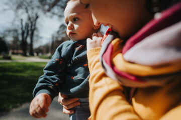 A tender moment between a mother and her child outside, focusing on the connection and warmth of...