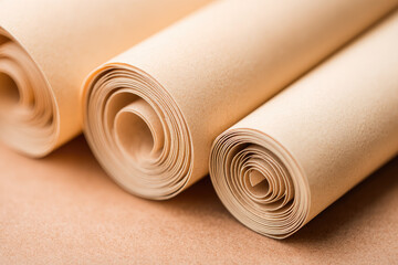 Three rolled sheets of archival receipt paper with clean shadows, soft beige color, and smooth texture, ideal for documentation, crafting, or artistic projects in calm setting