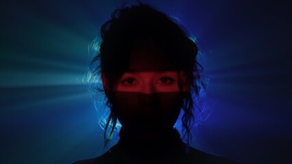 Mysterious female portrait in red and blue light beams